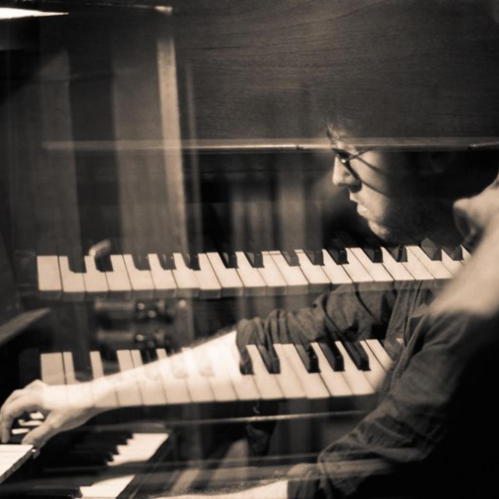 Seitenportrait s/w Komponist und Performancekünstler James Rushford überblendet mit Klaviertastauren
